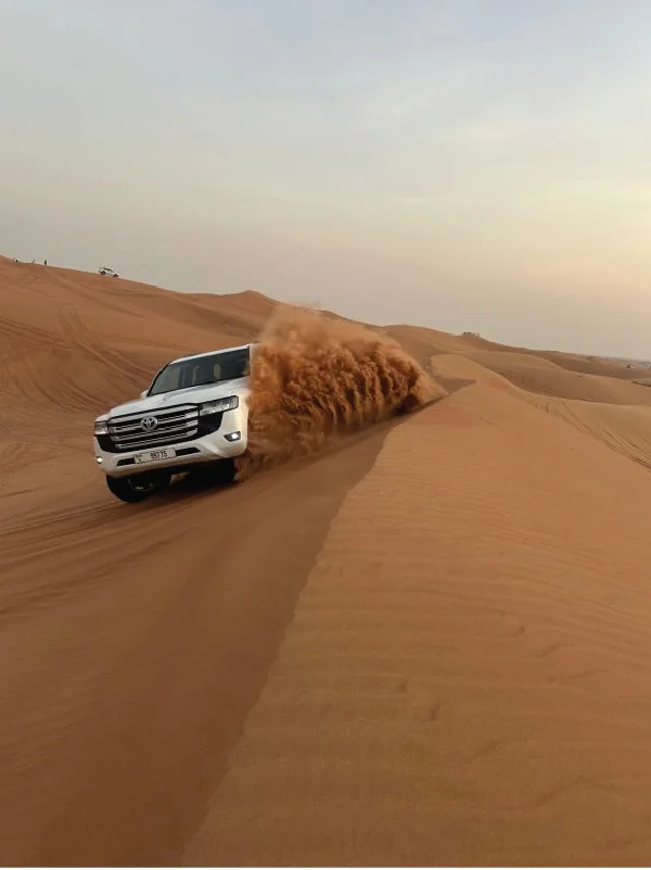 A 4×4 driving through the golden dunes of the Dubai desert